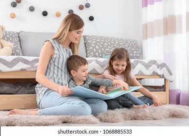 Nanny Reading Book To Little Children At Home