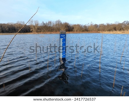 NAP Normaal Amsterdams Peil (Normal Amsterdam Level) board in a lake in the Netherlands that indicates that the water is higher than the average sea level of the North Sea due to climate change