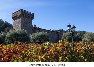 NAPA VALLEY, CALIFORNIA - November 8, 2016 : Castello Di Amorosa's Turret Rising Above Large Olive Trees And Fall Grape Vine Leaves On November 8, 2016 In Napa Valley, California.