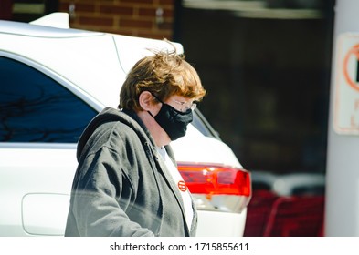 Naperville, IL - 4/16/20: Elderly Female Grocery Store Worker Wearing A Fabric Mask To Protect Against Contracting COVID 19 While Working During The Global Coronavirus Pandemic