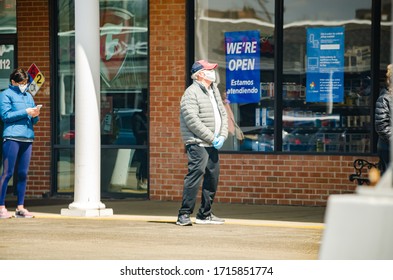 Naperville, IL-4/16/20: Elderly Man Wearing Mask And Gloves Waiting In A Long Grocery Line While Maintaining Social Distancing Guidelines To Protect Against The Spread Of COVID 19 During A Pandemic