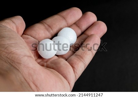 Naphthalene balls on the hand With Black Background