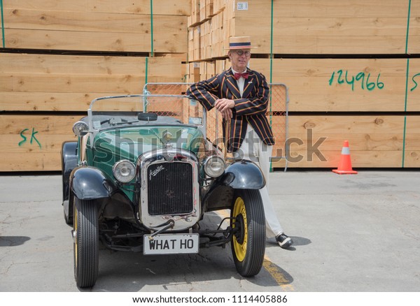 Napier, Hawke\'s Bay/New\
Zealand-December 15,2016: Man in vintage style jacket and hat\
resting on vintage Austin luxury convertible car in Napier, New\
Zealand