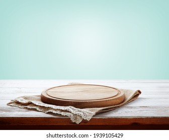Napkin and board for pizza on wooden desk closeup. Canvas, dish towels on white wooden table background top view mock up. Selective focus.