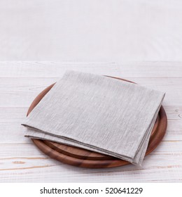 Napkin On Table In Perspective. Napkin Close Up Top View Mock Up For Design. Frame Of Round Cutting Board And White Tablecloth. Place For Text