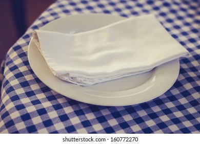 Napkin And Plate On Checkered Table Cloth