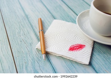 A napkin with a red kiss with a handle on a light table in a close-up, a wooden table in blue - Powered by Shutterstock