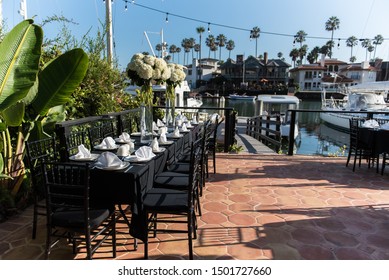 Napkins Folded Neatly In Preparation For Large Group Dinner Event Held On Outdoor Deck And Dock Leading Out To Canal Boats.