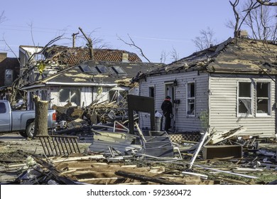 NAPLATE, ILLINOIS/USA - MARCH 3, 2017: A Young Woman Enters A Small House Severely Damaged By An EF-3 (enhanced Fujita Scale) Tornado That Devastated This Small Town On February 28.