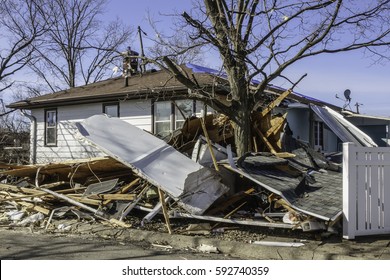 NAPLATE, ILLINOIS/USA - MARCH 3, 2017: Debris Lies Piled Up Near A Damaged House And Tree During Recovery From An EF-3 (enhanced Fujita Scale) Tornado That Blasted This Small Town On February 28.