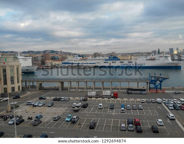 Naples,\
Italy - 04 Nov 2017: Partial view of Naples and the port with the\
parking area for maritime passengers\' cars. Photo is taken from a\
cruise ship while entering the port of the\
city.