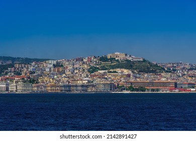 Naples, Italy City Center Coastal Sea View Under Cloudless Blue Sky With Castel SantElmo Medieval Fortress And Waterfront Buildings Visible From A Sailing Ship On The Gulf.