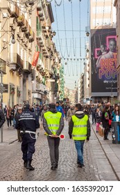 NAPLES, ITALY. January, 2020. Rear view of a metropolitan police officers, wearing high visibility jackets in Via Toledo, the busiest street of Napoli, during Christmas holidays.