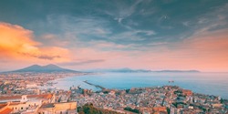 Naples, Italy. Top View Skyline Cityscape City In Evening Sunset. Tyrrhenian Sea And Landscape With Volcano Mount Vesuvius