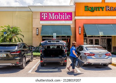 Naples, USA - August 7, 2021: Naples, Florida T-Mobile Office And Parking Lot Candid People And Equity Realty Real Estate Sign For Business In Strip Mall