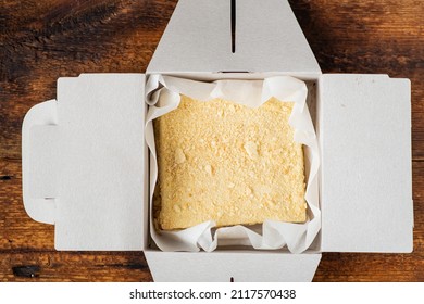 Napoleon Cake In A Cardboard Box. Dark Wooden Background. Sweet Gift. Delivery Of Confectionery.