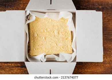 Napoleon Cake In A Cardboard Box. Dark Wooden Background. Sweet Gift. Delivery Of Confectionery.