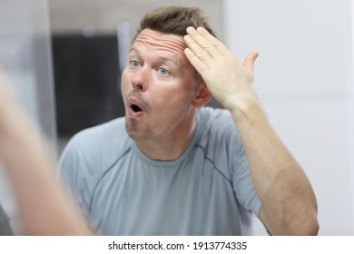 Narcissistic Man In Front Of Mirror Does His Hair. Psychological Portrait Of Male Narcissist Concept