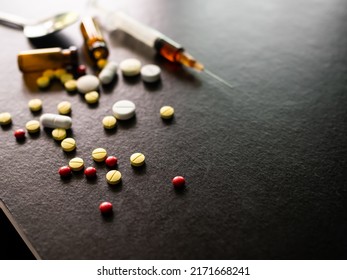 Narcotics Concept. Ecstasy Pills And Syringe On Black Wooden Table Background. Card And Poster For Speed Drug, Substance Abuse,illegal, Dangerous Substance,methamphetamine.