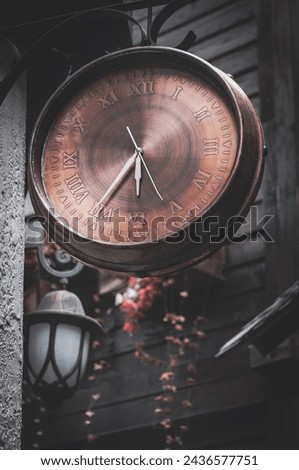 In the narrow alley, nestled amidst the aged brick walls and cobblestone pathways, stands a majestic antique clock, its presence a beacon of timeless elegance.