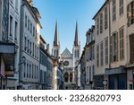 Narrow alley with picturesque houses, typical windows and church of St. Jacques in Pau, France.