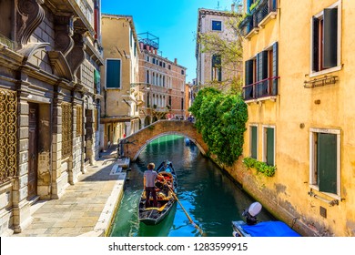Narrow canal with gondola and bridge in Venice, Italy. Architecture and landmark of Venice. Cozy cityscape of Venice.