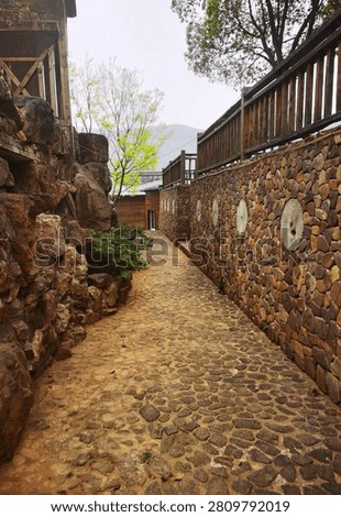 Narrow Cobblestone Lane Between Rustic Stone Walls