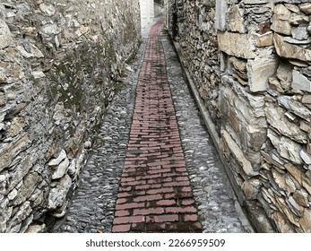 Narrow cobblestone path between two stone walls