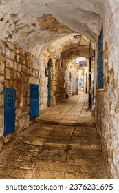 Calle empedrada estrecha o callejón en el barrio judío de la ciudad más elevada de Israel, Tzafet (Safed). Traducción de signos: Sinagoga del rabino Moshe Elsheich.