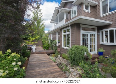 A Narrow Deck Goes Past Double Doors In The Backyard Of This Contemporary Home.