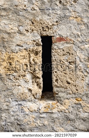 Narrow defensive arrow loop built into the historic stone walls of Lichtenstein Castle in Baden-Württemberg, Germany.