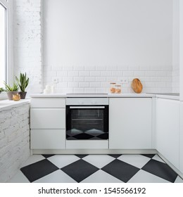 Narrow kitchen with white brick wall and chess mosaic tiles on the floor
