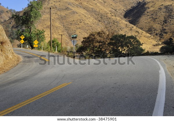 A narrow\
mountain road forks off the main\
highway