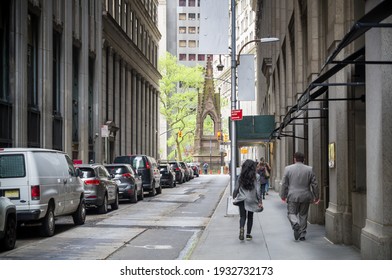A Narrow New York City Street Facing Towards Trinity Church Situated Near Wall Street And Broadway. Narrow NYC Street. Busy Financial Center Of A City.