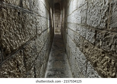 Narrow passage between castle walls made of stone blocks - Shutterstock ID 2157534125