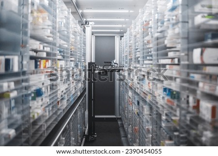 Narrow pharmacy aisle flanked by towering shelves stocked with medicine boxes. A pharmacy robot navigates through, ensuring efficient and precise medication retrieval.
