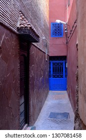 Narrow Purple Alleyway With Cobalt Blue Door In Souk Of Marrakech, Morocco - November 12, 2010