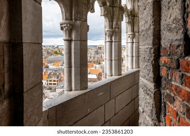 The narrow stone passageway with arched windows looking out over the city at the top of the medieval Belfort van Gent, Belfry of Ghent, in the city center of Ghent, Belgium.