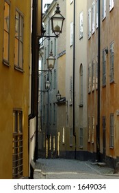 Narrow street with an array of street lights hanging from buildings