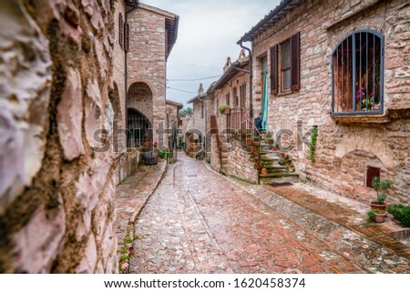 Narrow street with brick walls in a town, Italy.