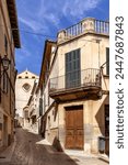 Narrow street Carrer de Monti-Sion with Esglesia de Monti-Sion in Pollenca, Mallorca, Spain, Balearic Islands