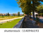 narrow street, colorful houses, old buildings and facade with green riverscape in old part of Parma, italy     