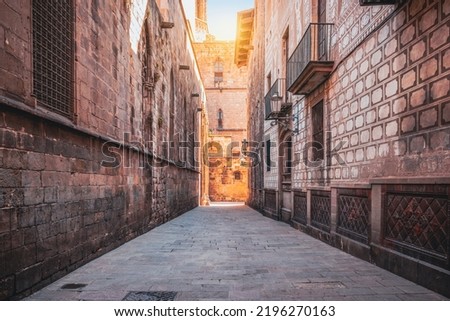 Narrow street with historic architecture close to cathedral in Barcelona city center, Spain.