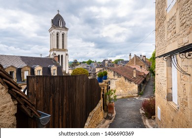 Narrow street of Montignac with a view of the church tower rising above the village