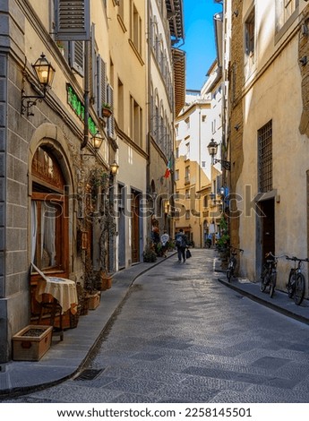 Narrow street with old trattoria in Florence, Tuscany, Italy. Architecture and landmark of Florence. Cozy Florence cityscape
