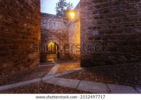Narrow street. Rear view of Puerta de Alcantara, historical landmark in Toledo, Spain