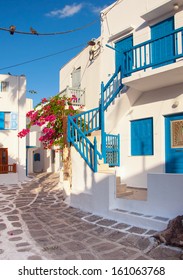 The narrow streets of the island with blue balconies, stairs and flowers. - Shutterstock ID 161063768