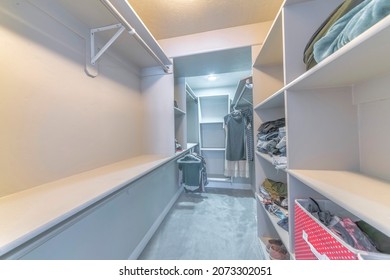 Narrow Walk-in Closet Interior With Open Shelving Unit