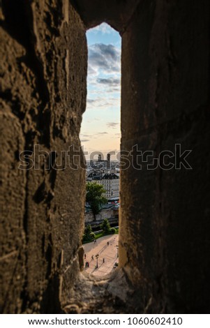 Schmales Fenster in der Steinmauer mit Blick auf das Pariser Stadtbild