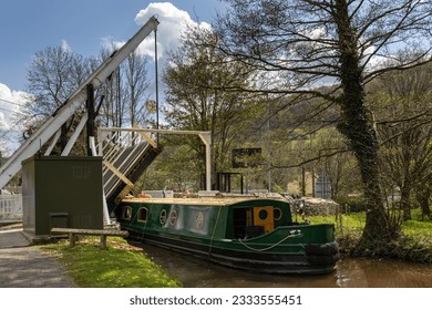 A narrowboat passes through the lift bridge at Talybont-on-Usk on the Monmouthshire and Brecon Canal, Brecon Beacons, Wales.